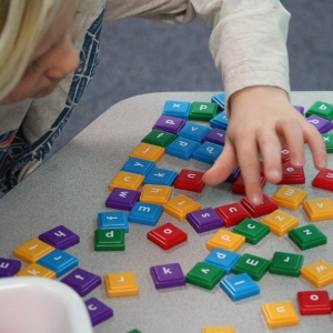 student playing with letter tiles